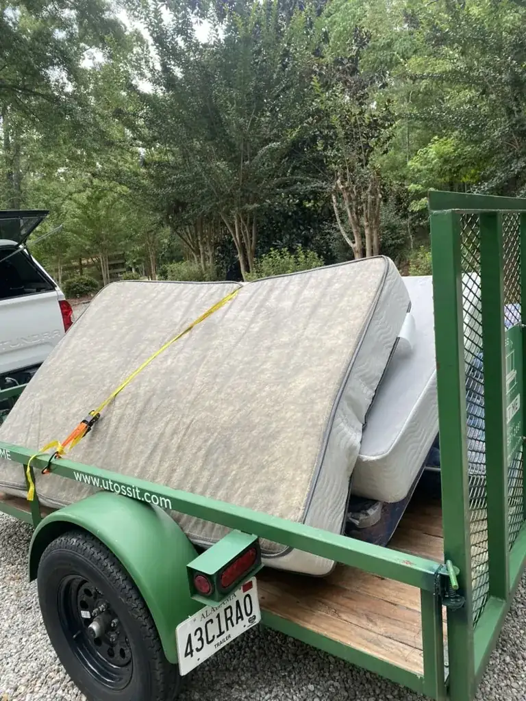 Toss It trailer loaded with mattresses and furniture during a Lake Martin property cleanout