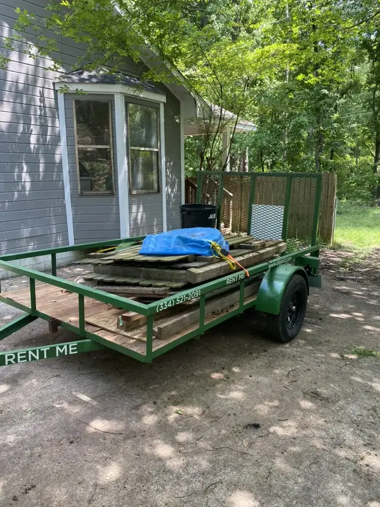 Toss It branded utility trailer loaded with debris on a customer job in East Alabama