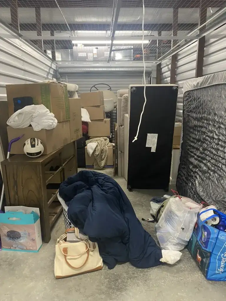 Auburn storage unit packed with furniture, mattresses, boxes and household belongings before a Toss It move-out cleanout